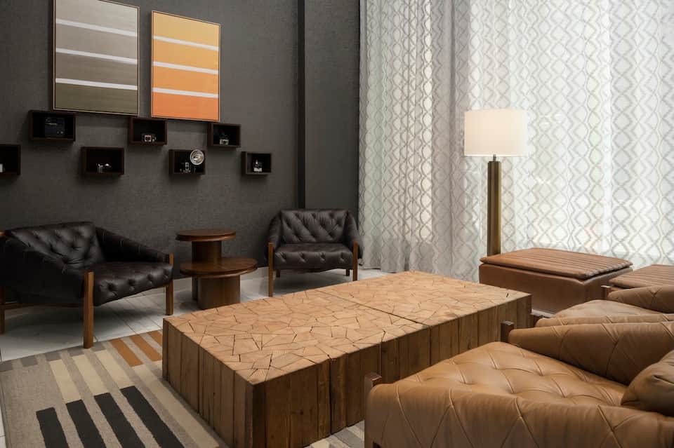 Modern spa relaxation lounge with black leather seating, wood tables, and neutral decor