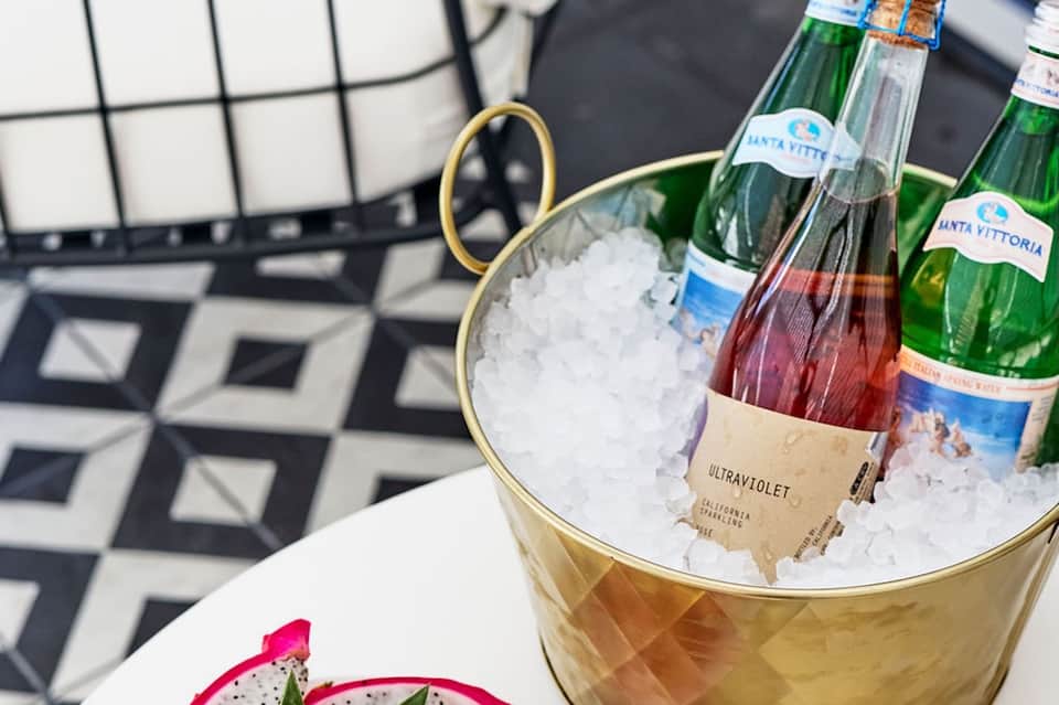 Gold ice bucket with champagne bottles on white table at upscale resort dining venue