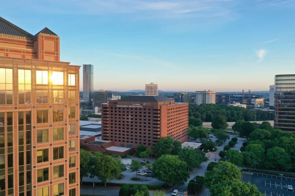 Urban cityscape at golden hour showing Renaissance hotel with surrounding buildings and trees