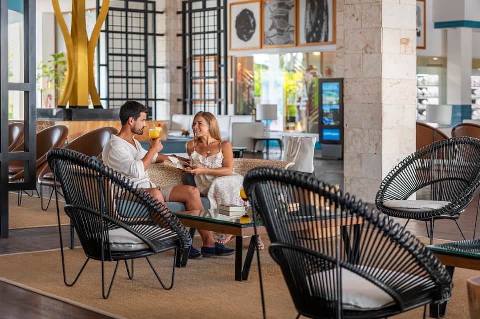 Couple dining together in modern resort lounge with contemporary furniture and stone accents