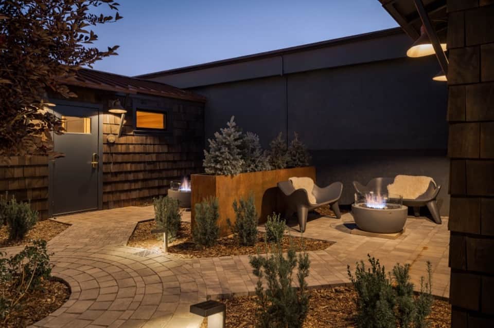 Contemporary courtyard with firepit, modern seating, landscaping, and evening lighting