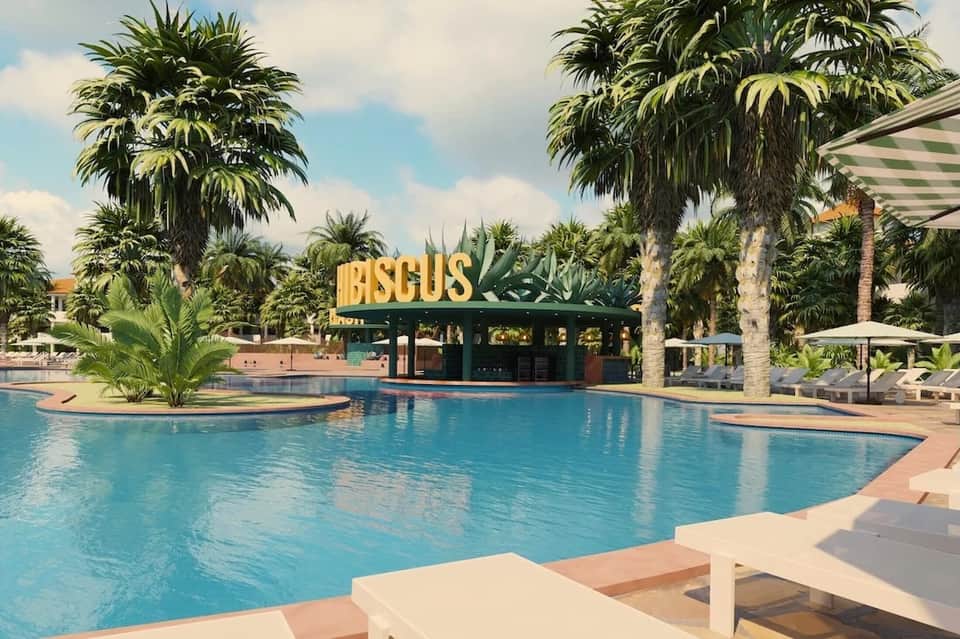 Tropical resort pool area with palm trees, blue water, 'DISCUS' bar sign, and white umbrellas