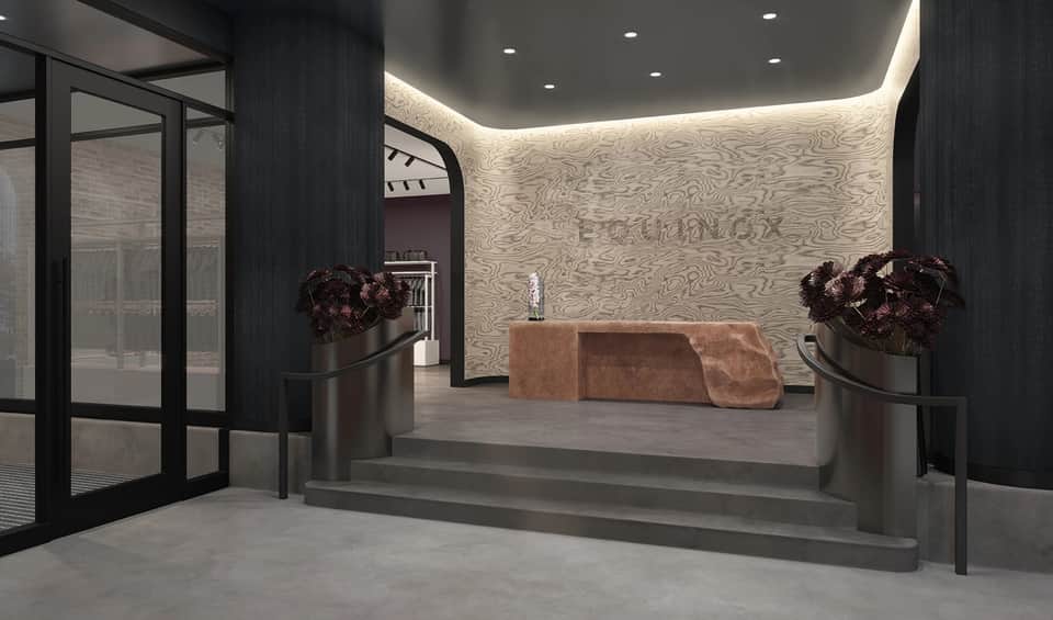 Contemporary hotel lobby entrance with dark wood accents, decorative planters, and ambient lighting