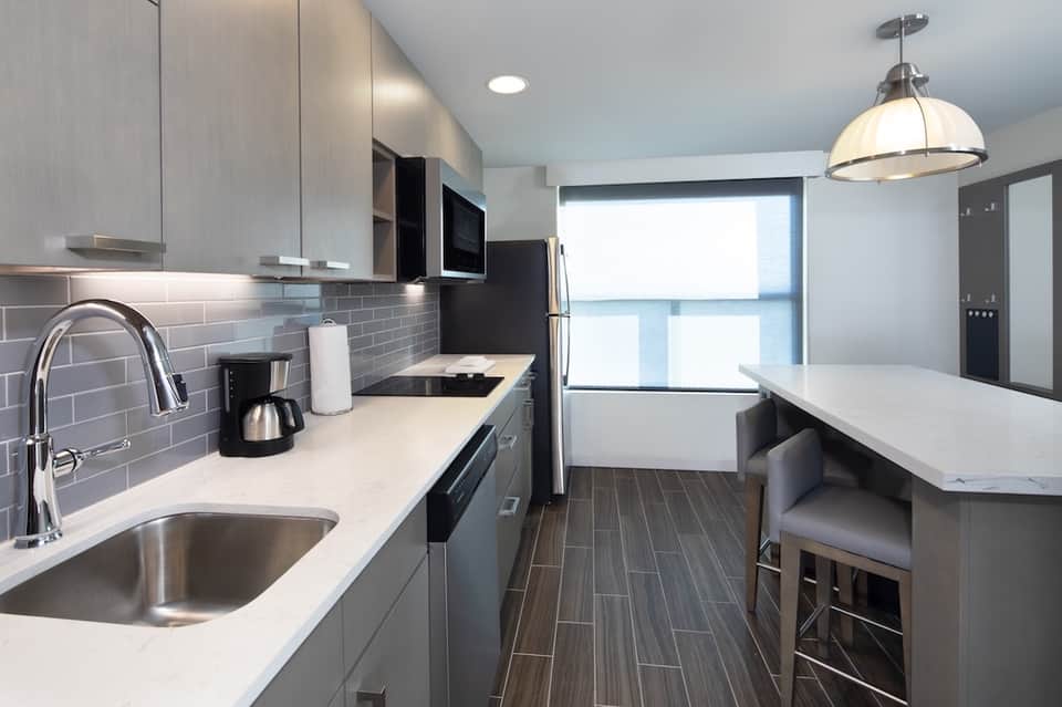 Contemporary kitchen with gray cabinets, subway tile backsplash, and stainless appliances