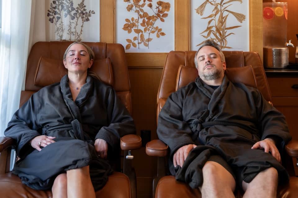 Two guests relaxing in lounge chairs at spa lounge