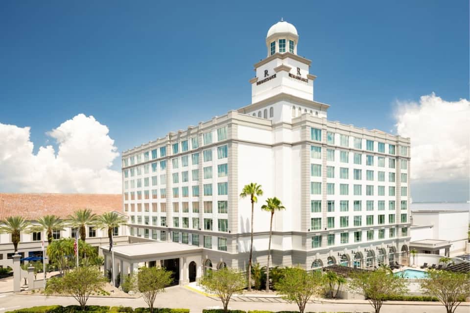 Historic beachfront hotel exterior with white neoclassical architecture and landmark tower