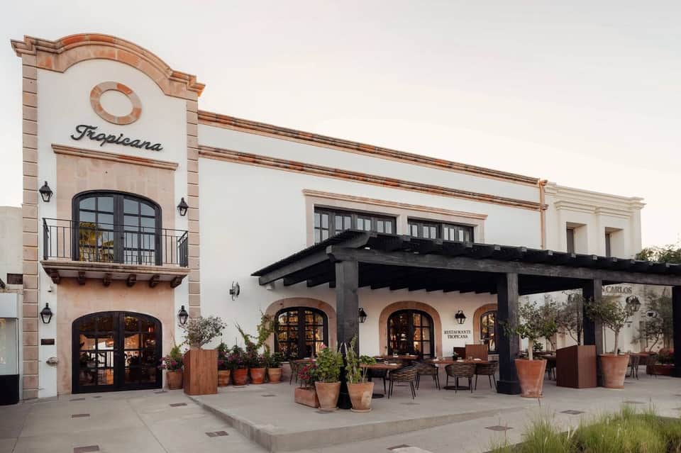 Mediterranean-style building exterior with Tropicana signage, terracotta accents, and covered patio seating.