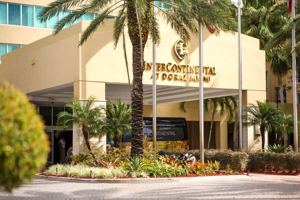InterContinental hotel entrance with cream-colored facade, palm trees, and landscaped grounds