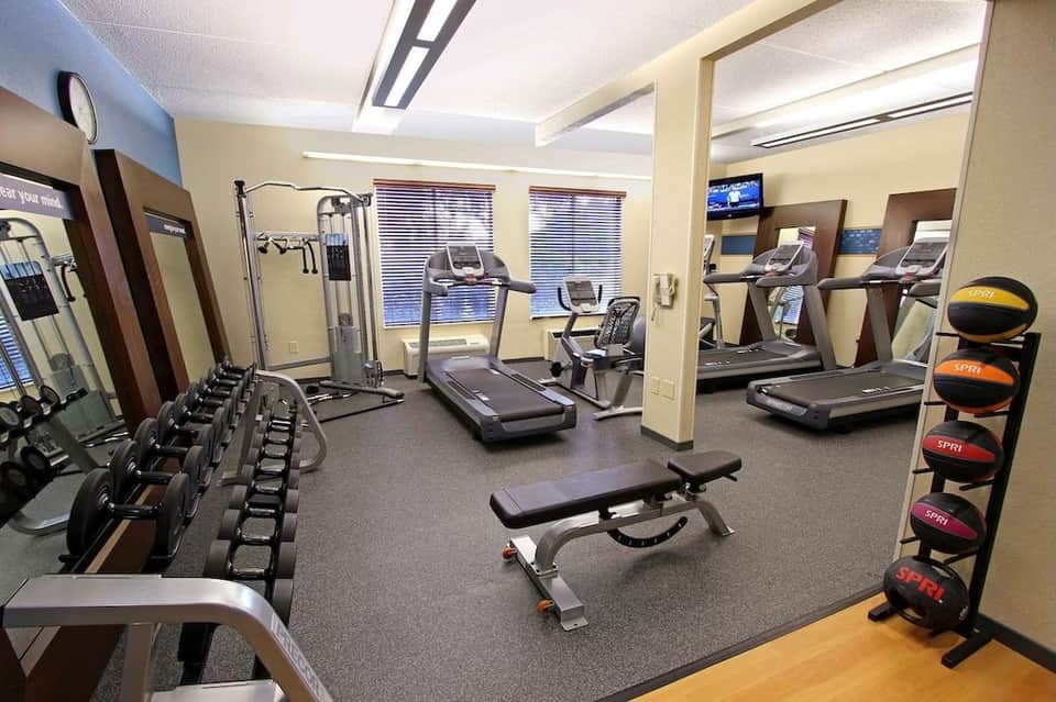 Fitness center with treadmills, dumbbells, weight machines, and exercise equipment