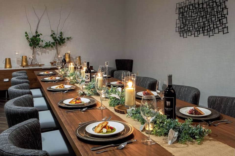 Elegant private dining room with long wooden table, place settings, candles, and floral centerpiece