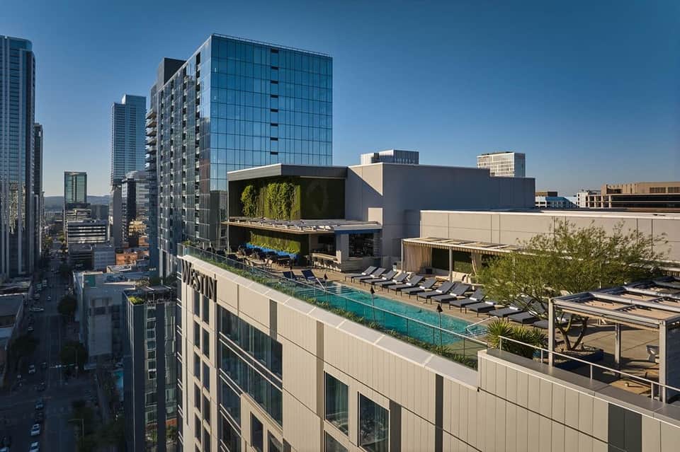 Elevated rooftop pool with lounge seating and downtown Austin cityscape view