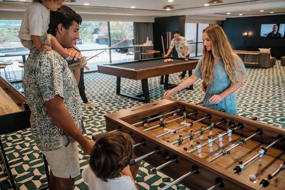 Game room with foosball table, pool table, and guests playing recreational activities