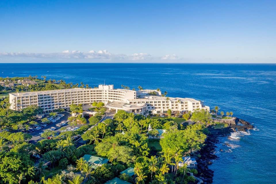 Clifftop beachfront resort complex nestled in lush tropical vegetation overlooking ocean