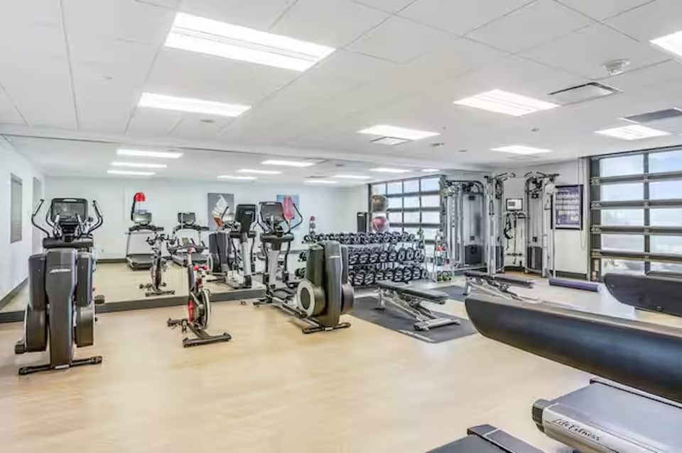 Bright fitness center with cardio equipment, weights, and strength training machines