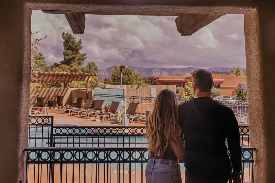 Couple viewing desert landscape and red rock formations from hotel balcony