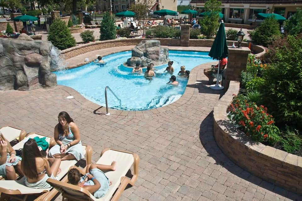 Resort courtyard pool with rock features, lounge chairs, and surrounding landscaping