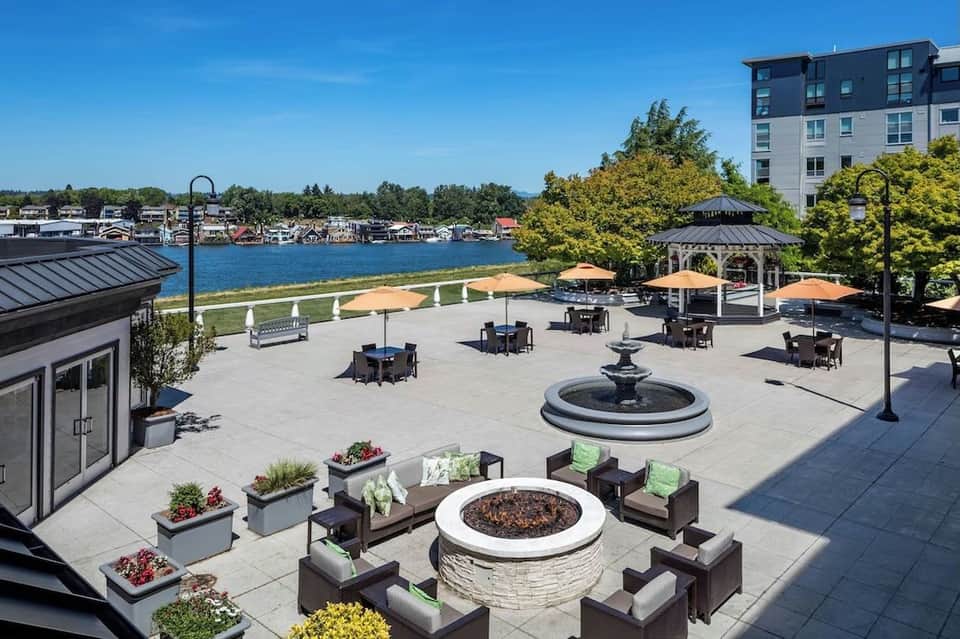 Waterfront patio with fire pits, seating areas, umbrellas, gazebo, and view of river and boats