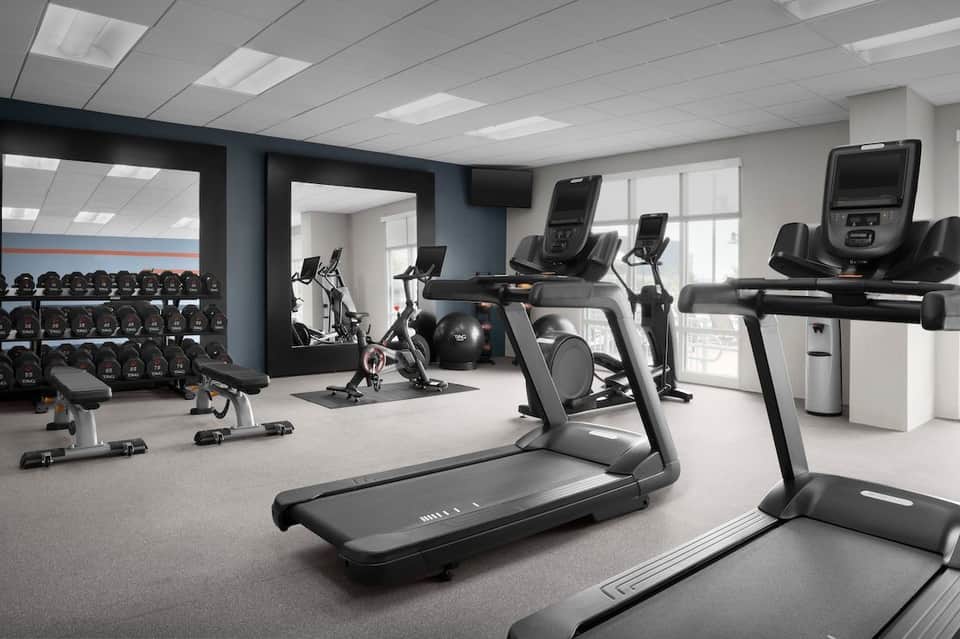 Modern hotel fitness center with treadmills, exercise bikes, and strength equipment