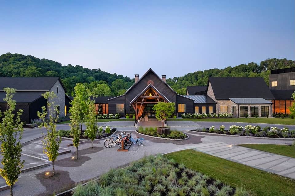 Modern luxury resort with dark architectural buildings, manicured grounds, and bicycles in central courtyard