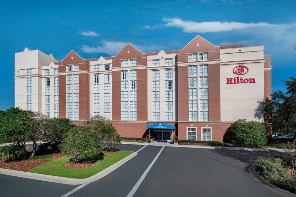 Hilton hotel exterior, red brick building with white trim under blue sky