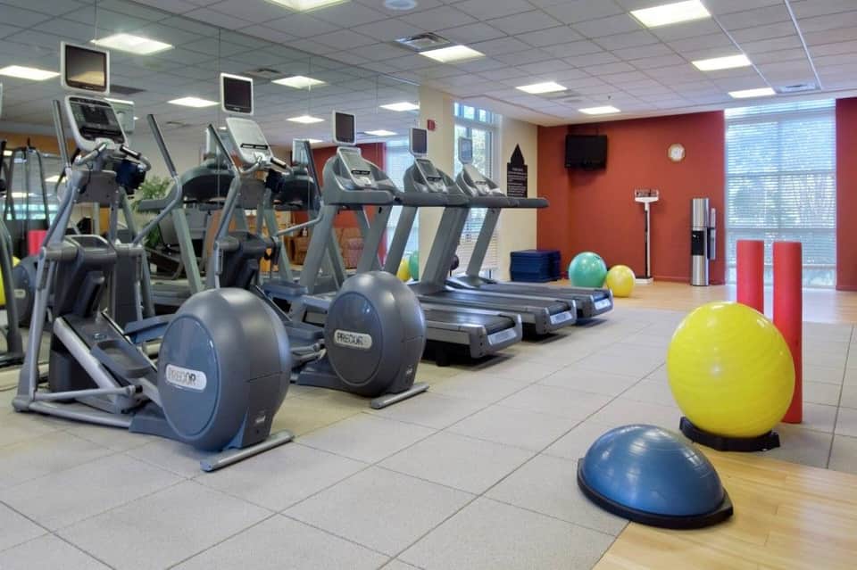 Hotel fitness center with cardio equipment, exercise bikes, and fitness balls on floor