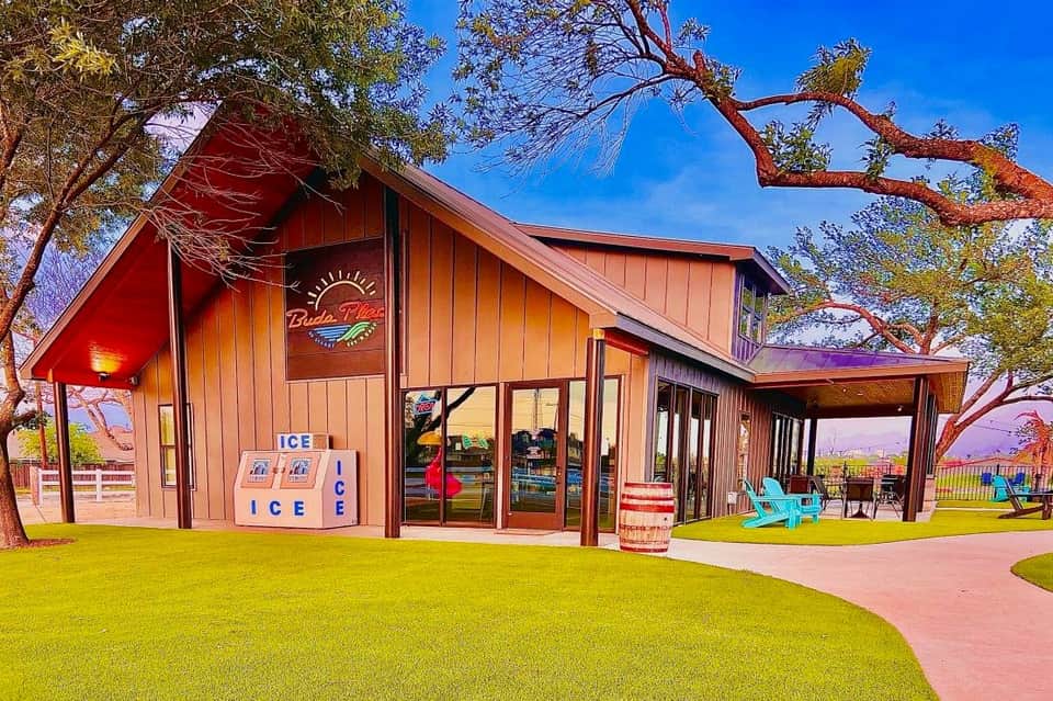 Rustic red barn building with ice service, coastal style architecture, and scenic waterfront views