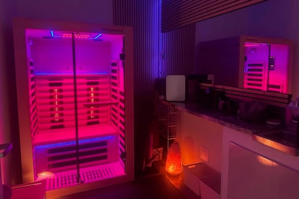 Modern infrared sauna cabin with pink and blue neon lighting in spa facility