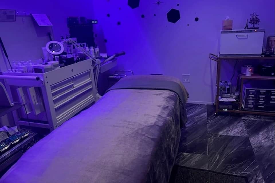 Bedroom with purple ambient lighting, bed, tool cabinet, and computer equipment