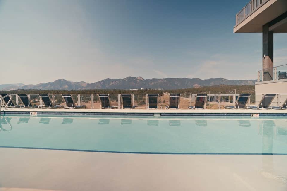 Rectangular resort pool with mountain views and lounge chairs in scenic desert landscape