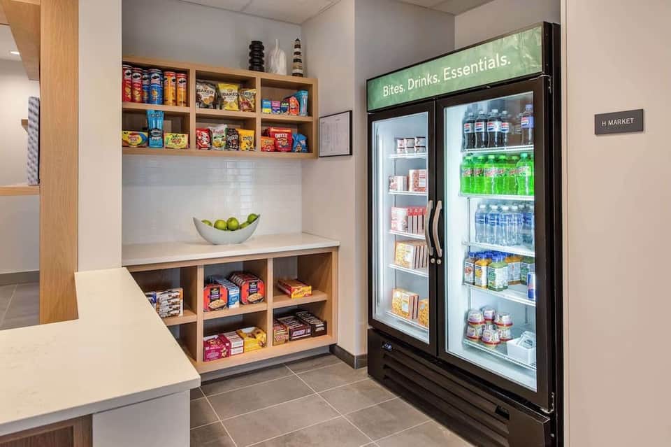 Hotel market and convenience store with shelving of snacks, drinks cooler, and wooden cabinetry