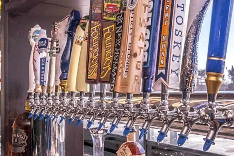 Beer tap wall display featuring multiple craft and domestic beer handles with branded tap markers