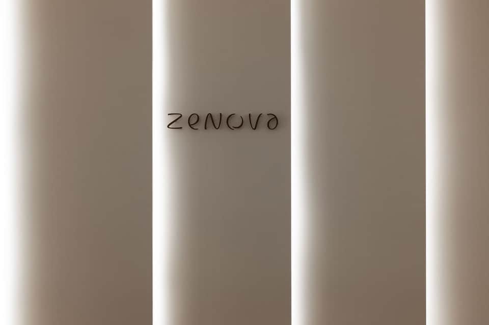 Modern corridor with Zenova signage, illuminated vertical panel walls, and neutral palette
