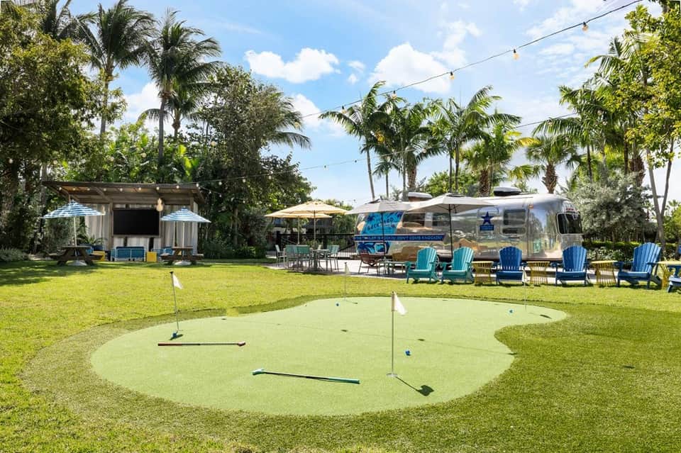 Resort grounds with Airstream trailer, mini golf course, and palm trees