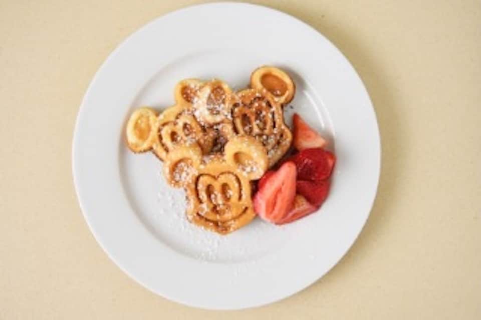 Decorative waffle cookies shaped like teddy bears with strawberries on white plate