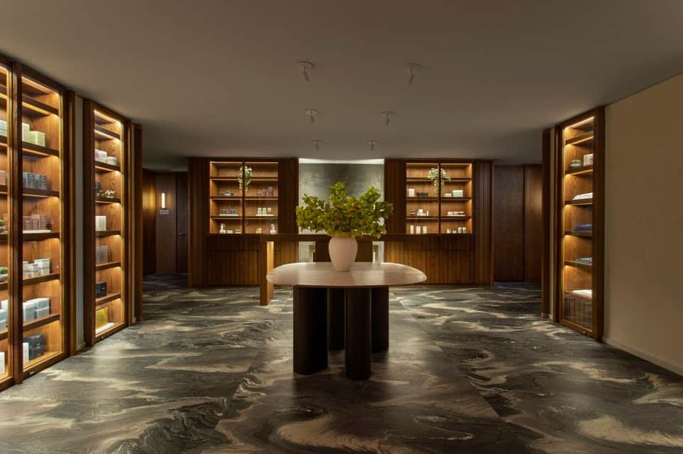 Upscale spa retail space with illuminated wooden shelving and central display table