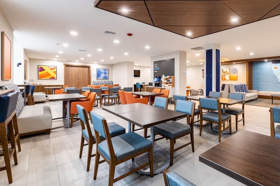 Hotel lobby lounge area with dining tables, chairs, and contemporary interior design