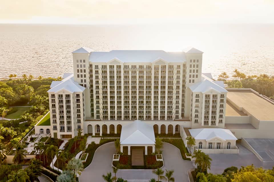 Beachfront resort exterior with cream-colored building and waterfront setting at sunset