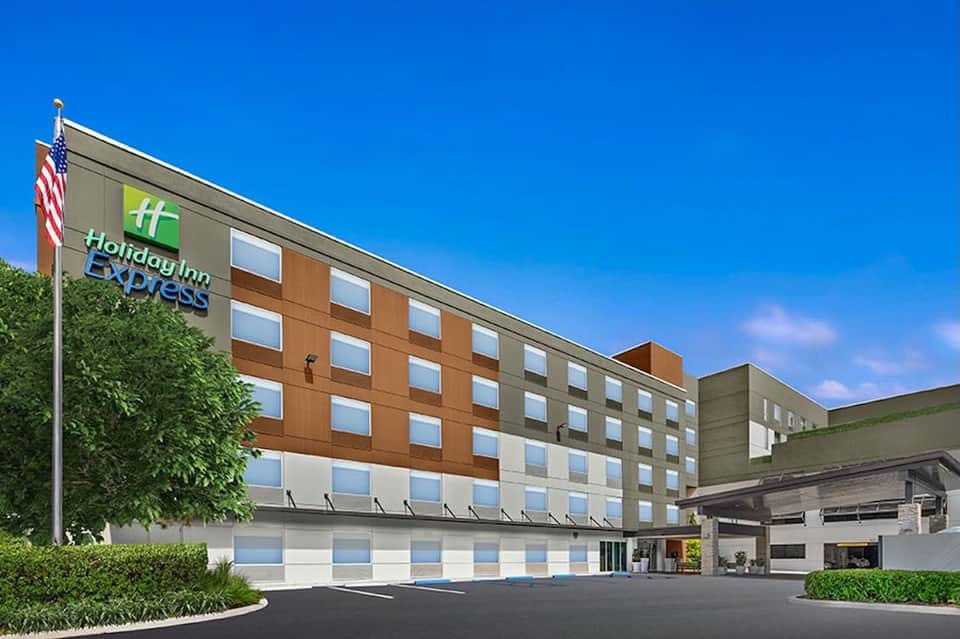 Holiday Inn Express exterior showing multi-story building with orange and tan facade and American flag