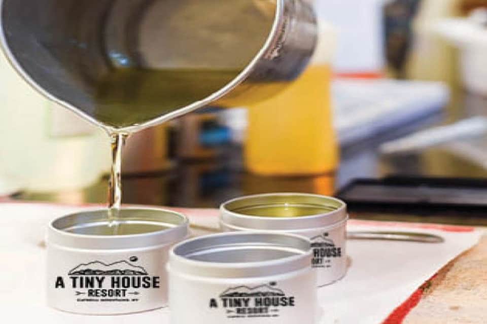 Paint being poured into white containers labeled 'A Tiny House Resort' during construction or renovation