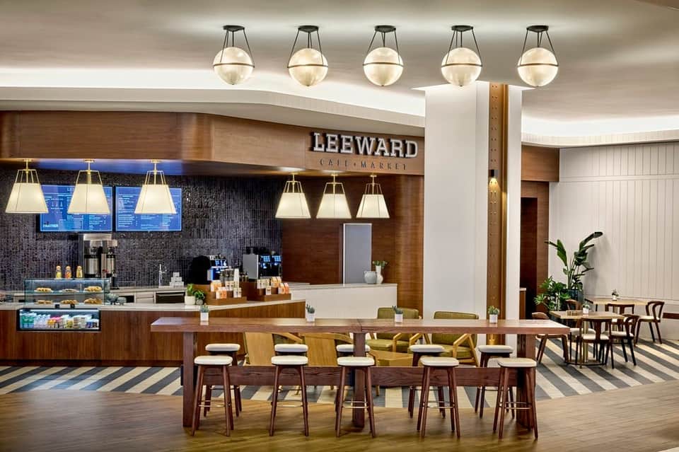 Café interior with wood paneling, pendant lighting, and dining area with striped floor pattern