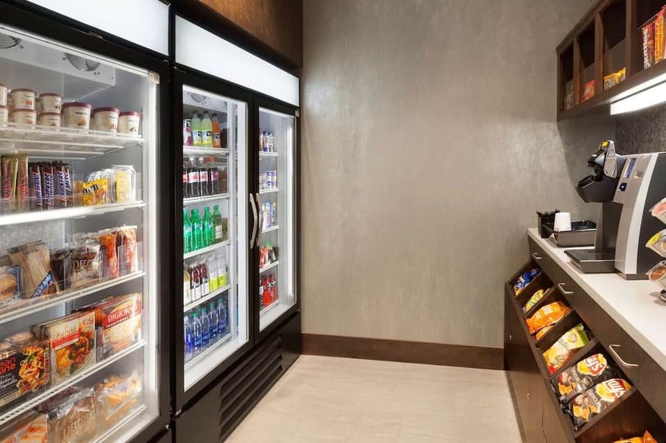 Hotel convenience store with refrigerated cases, beverages, and snack displays