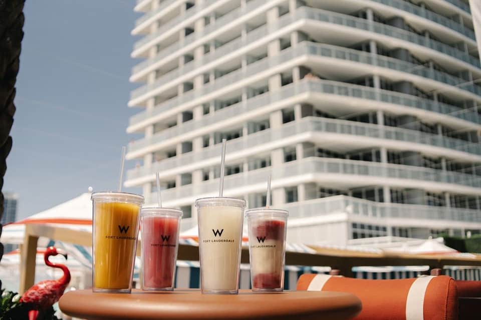 W Fort Lauderdale branded beverages displayed at resort pool bar with hotel tower backdrop