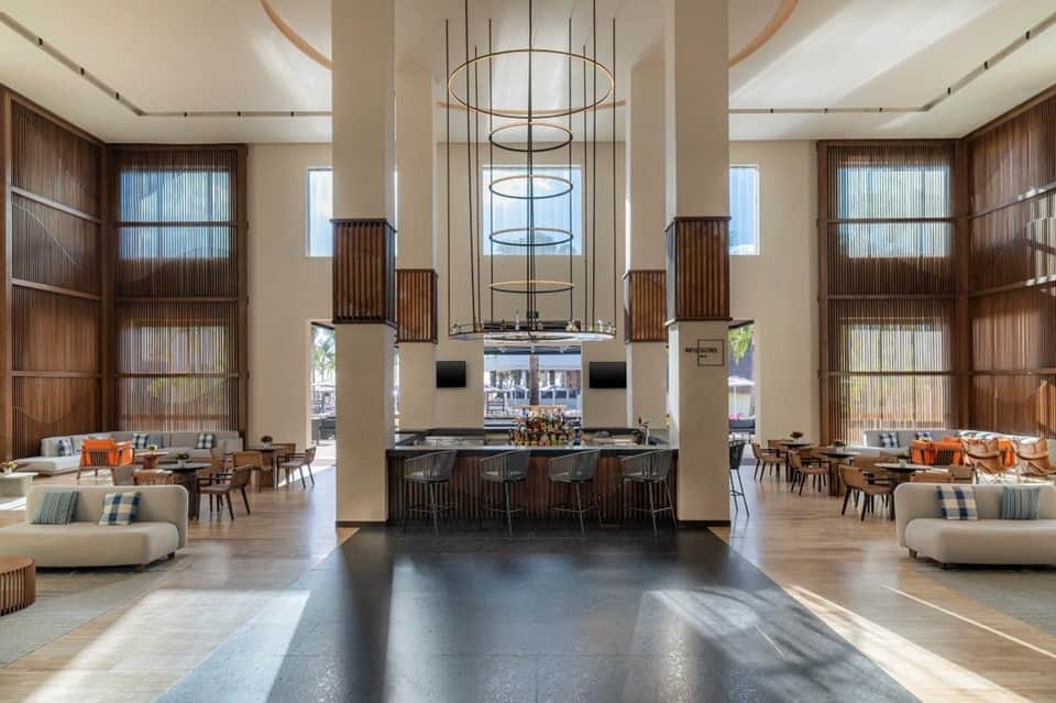 Grand hotel lobby with suspended circular chandeliers, high ceilings, and seating areas