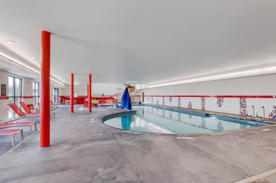 Indoor pool with red columns, lounge chairs, and shallow children's pool area