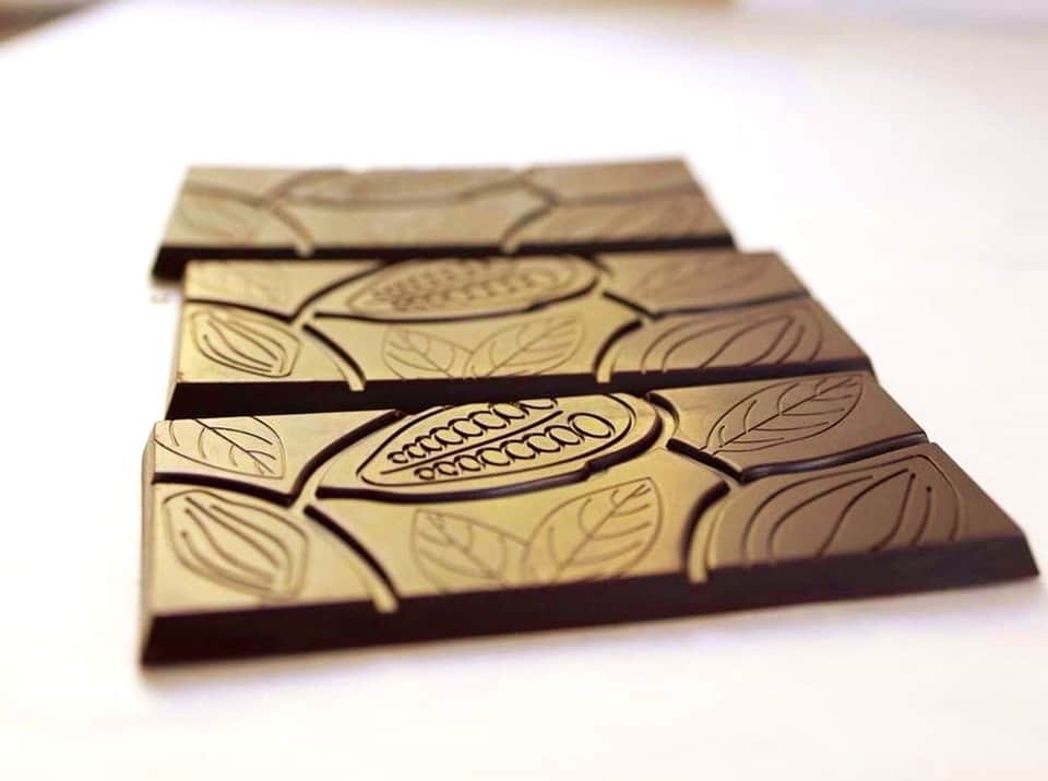 Artisanal chocolate bars with cocoa pod designs and dark chocolate coating