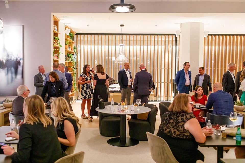 Modern hotel lounge with vertical wooden screens and guests mingling at event