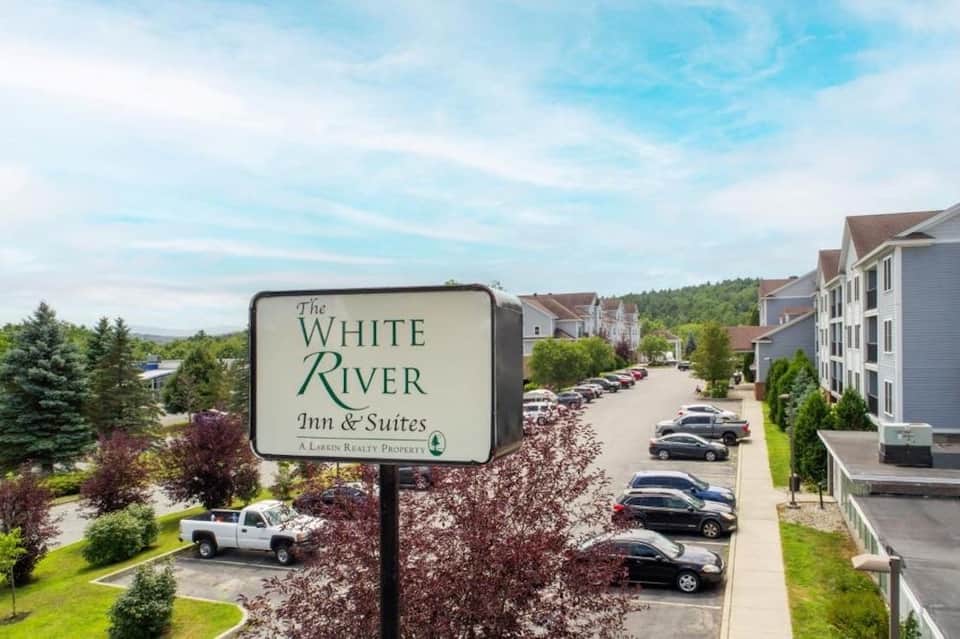 White River Inn & Suites property sign with multi-building resort complex in background