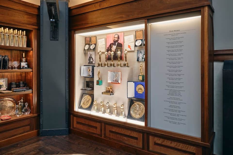 Luxury display case with wooden cabinetry, collection of awards, trophies, and glass shelving