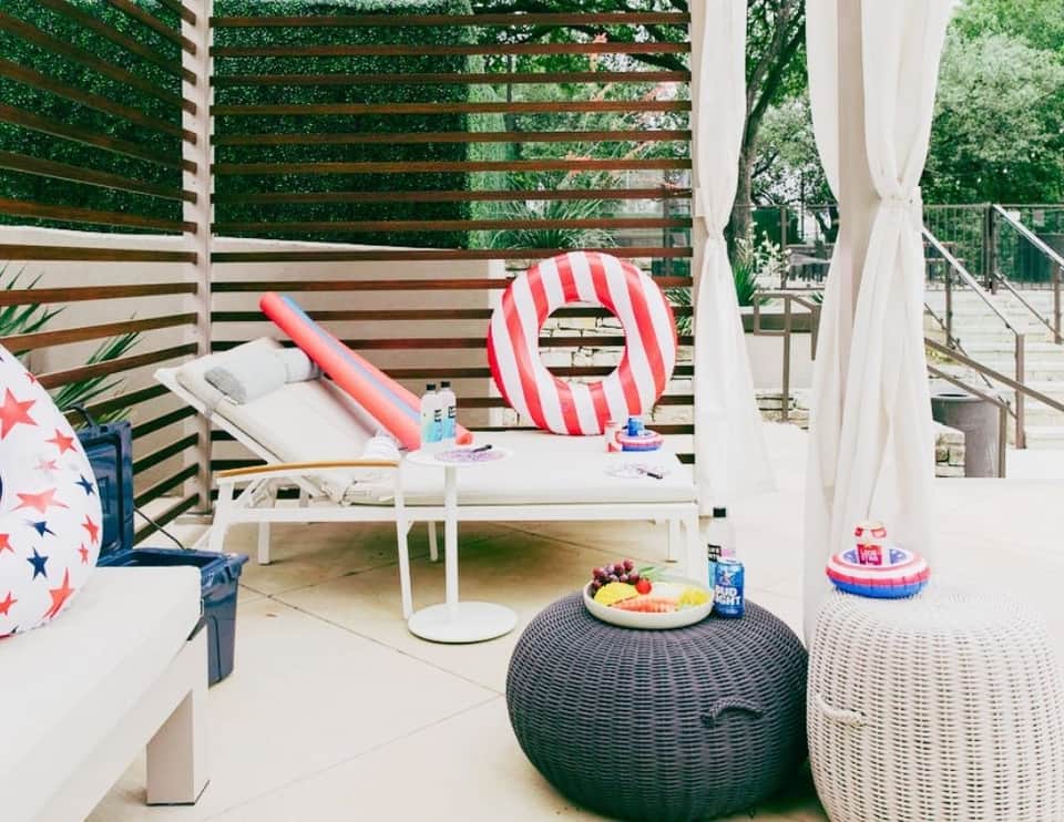 Patriotic poolside setup with striped float, lounge chair, and beach balls