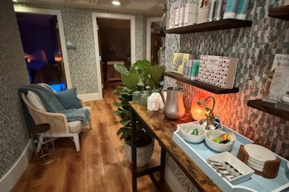 Wellness center reception area with patterned wallpaper, wood shelving, and modern spa amenities